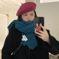 Thick knitted teal green scarf and magenta beret hat worn by a model in a cozy indoor setting - Peacock Blue