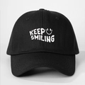 Dettaglio ravvicinato del ricamo KEEP SMILING su un cappellino in cotone nero - Taglia unica / Nero