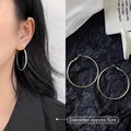 Detail shot of 5cm large gold hoop earrings showing fine brushed texture and scale on model - 5cm / Minimalist Hoop / Gold