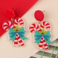 Festive Christmas candy cane earrings with green bows and glitter finish on red background - Bow Candy Cane