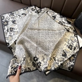 Silk square scarf with floral print and black border draped on a leather couch - 70*70cm / 30318-Beige Black White Floral