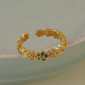 Detalle macro de anillo de flores doradas con esmalte blanco y verde y pequeños cristales - Oro de 18K+Verde+Blanco