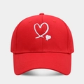 Close-up of a red baseball cap with white heart embroidery and fine canvas texture - Adjustable / Red