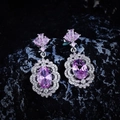 Macro detail of luxury pink zircon earrings featuring floral design on a dark stone - Pink Rhinestone Stud Earrings