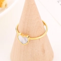 Anillo de corazón dorado en acero inoxidable con inserto blanco en soporte de madera - Concha de Corazón Dorado (KR106175-K)