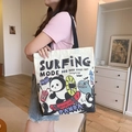 Off-white canvas tote bag featuring a surfing panda graphic and black shoulder straps - Skateboarding Panda