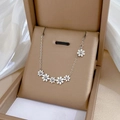 Detalle de collar con flores de margarita plateadas en una caja de regalo beige elegante - Plateado (M114 Plateado)