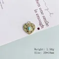 Dettaglio del ciondolo a cuore dorato con pietra turchese, trama martellata, 20x18mm - 1# Cuore Oro Turchese