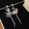 Macro detail of silver hollow petal earrings with zircon and delicate fringe tassels - Silver