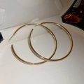 Close-up of golden hoop earrings with a polished finish inside a white jewelry box - Classic Large Gold Hoop Style (Silver Earring Post)