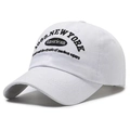 Detailed close-up of a white cotton baseball cap with 1969 New York black embroidery - White