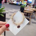 Élastique à cheveux perlé en cristal rose avec pendentif doré gravé - Rose