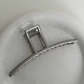 Detailed view of silver metal bow shark hair claw clip with polished finish and sleek teeth - Grey Silver - Bar Shape