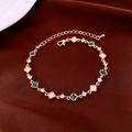 Dettaglio macro del bracciale a quadrifoglio dorato con malachite verde e zirconi chiari - Oro Verde
