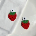 Detalle de pendientes de fresa en acrílico con pequeña flor blanca sobre una base de cerámica - Perno de Flor Fresa Color Sólido