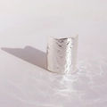 Brede zilveren ring met lavatextuur en prachtige waterrimpel lichtreflecties erop - Zilver