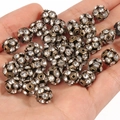 Macro detail of 18k gold plated hollow crystal spacer beads held in hand for jewelry DIY - Yangmei Ball Gun Black White Rhinestone