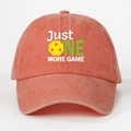 Detailed macro view of embroidered Just One More Game slogan on a vintage washed baseball cap - Orange