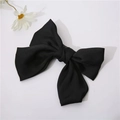 Detailed view of the large black satin fabric bow hair clip on a minimalist white background - Black