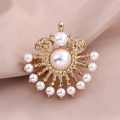 Elegant gold vintage brooch featuring a large center pearl and ornate cutout metal details - Radiant Pearl (10446)