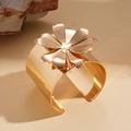 Macro detail of polished rose gold flower cuff bracelet with high mirror finish - Gold