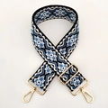 Close-up of geometric ethnic pattern wide strap with rotating gold metal hooks - Gold Clasp / Black White Blue Floral