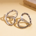 Macro detail of silver twisted irregular hollow heart earrings with polished finish - Silver