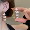 Detail of pink butterfly hoop earrings with gold trim on model and in hand close-up - 40# Pink Butterfly Enamel Large Hoop Earrings (Earring Post)