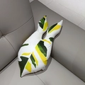 Detailed close-up of leaf shaped pillow with green veins on a dark leather sofa - Colorful Syngonium