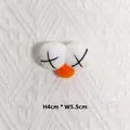 Détail macro d'accessoire en peluche avec yeux en X et nez orange, taille 4 cm par 5,5 cm - Œil Bleu avec Cils