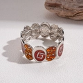Dettaglio del bracciale elastico argento con stelle in smalto arancione e accenti a forma di G - Base Argento Smalto Rosso-Arancio