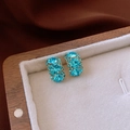 Boucles d'oreilles dorées avec cristaux bleu clair et petits diamants sur velours blanc - Boucles d'oreilles rondes en strass plaqué or 18 carats