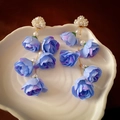Macro shot of blue fabric rose tassels and white pearl cloud stud on white ceramic - Blue Flower Tassel Earrings