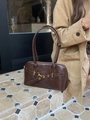 Close-up of brown faux leather bowling bag with gold metal buckle and dual straps - Coffee Brown