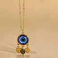Dettaglio della collana occhio di Allah dorata con zircone e tre ciondoli a cuore - Pendaglio a Cuore / Cuore Blu Reale