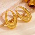 Detailansicht großer goldener Creolen mit Spiralstruktur auf einer Steinfläche - Gewinde Hohl Stil (F715) / Gold