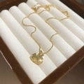 Gros plan d'un collier avec pendentif cheval à bascule doré dans un écrin de luxe - 13# Collier-Or-Cheval à bascule 3D (Plaqué or réel)