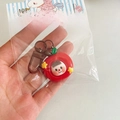 Macro detail of apple-shaped Christmas keychain with cute character and red finish - Apple / Red