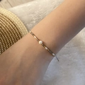 Bohemian woven pearl bracelet with gold and silver beads on a person's wrist - Grey