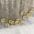 Detailed macro view of gold stainless steel rectangular floral pendants with ribbed edges - Steel Floral Style