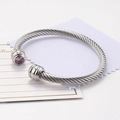 Silver twisted cable open cuff bracelet featuring a round purple zircon stone accent - October/Pink