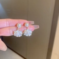 Detailed macro view of white enamel camellia earrings with pearls and gold plating - Style 29 (White)