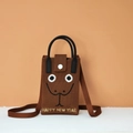 Detail of a brown knitted crossbody phone bag featuring a smiley face and a snap closure - Snake Emoji (Coffee)