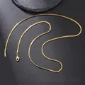 Detail of golden stainless steel snake chain with lobster clasp on a dark surface - Snake Chain