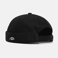 Detail view of black cotton brimless cap featuring white embroidery and adjustable back strap - Adjustable / Black