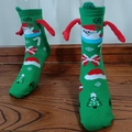 Green Christmas magnet hand-holding socks with festive Santa and tree patterns - Green Santa 3D Hand