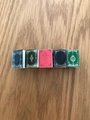 Detailed macro view of five miniature notebook hair clips in assorted retro colors on wood - 2# Red Book Clip