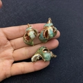 Three natural green shell pendants with golden electroplated edges held by hand - No.31 (Green Shell - Gold Edge)