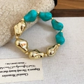 Detailed close-up of retro acrylic bracelet with turquoise beads and gold spacers - Bracelet / Blue