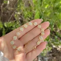 Dettaglio del bracciale a fiori placcato oro 18K con zirconi indossato al polso - Fiore Cavo